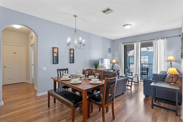 4862 Cayview Ave Unit 407, Orlando, FL 32819 - dining space featuring arched walkways, visible vents, baseboards, and wood finished floors