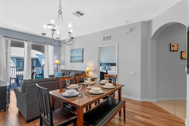 4862 Cayview Ave Unit 407, Orlando, FL 32819 - dining space featuring arched walkways, light wood finished floors, and visible vents