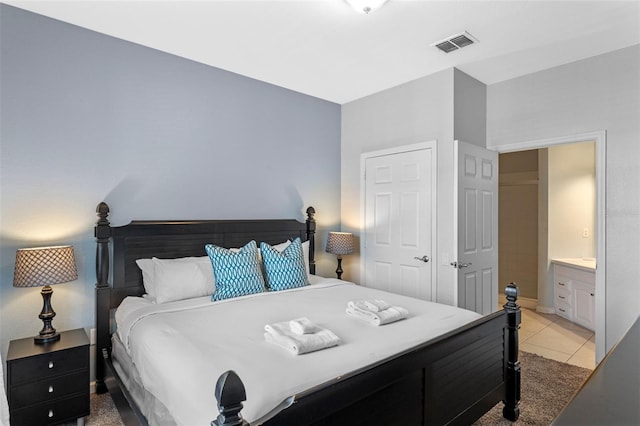4862 Cayview Ave Unit 407, Orlando, FL 32819 - bedroom with visible vents, ensuite bathroom, and light tile patterned flooring