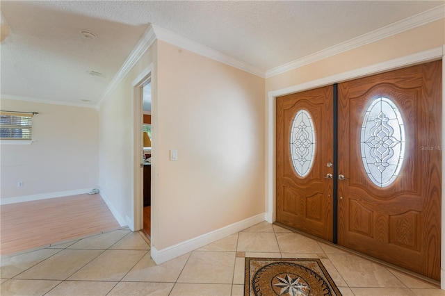 foyer entrance with light tile patterned floors, baseboards, and ornamental molding
