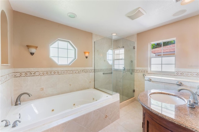 full bath with tile patterned floors, tile walls, a whirlpool tub, a wainscoted wall, and a stall shower