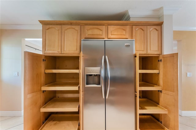 kitchen featuring crown molding, light brown cabinetry, stainless steel fridge, and baseboards