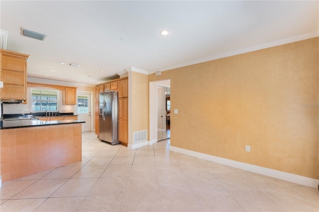 kitchen featuring stainless steel refrigerator with ice dispenser, visible vents, crown molding, and dark countertops