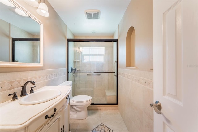 bathroom with visible vents, toilet, tile walls, a shower stall, and tile patterned flooring