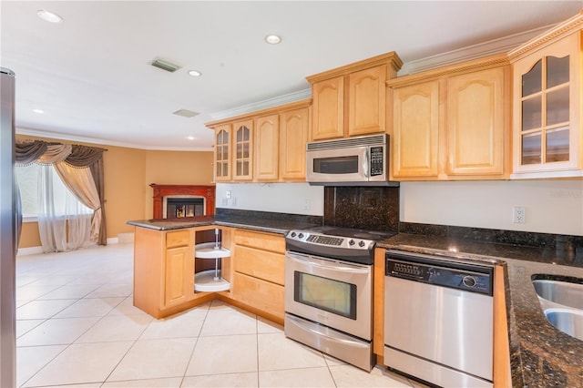 kitchen featuring stainless steel appliances, visible vents, light brown cabinets, and crown molding