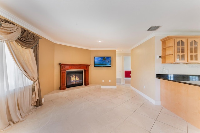 unfurnished living room featuring visible vents, baseboards, light tile patterned floors, crown molding, and a glass covered fireplace