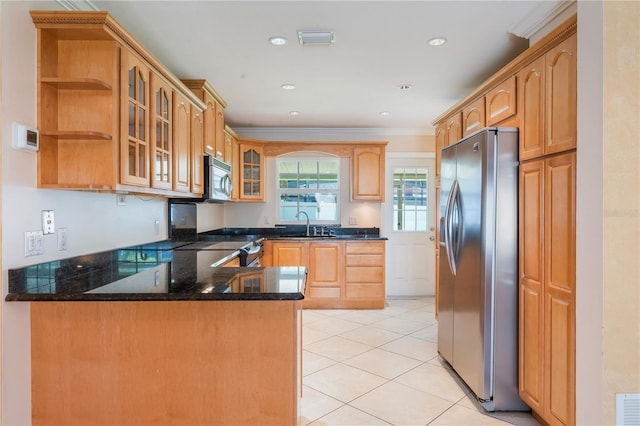 kitchen featuring a peninsula, glass insert cabinets, light tile patterned floors, stainless steel appliances, and a sink