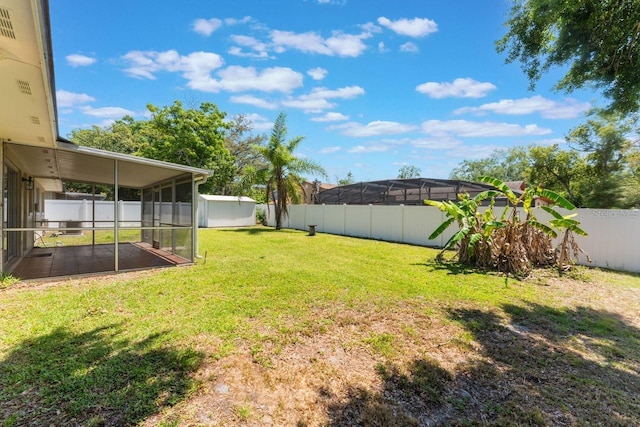 view of yard with a fenced backyard and a sunroom
