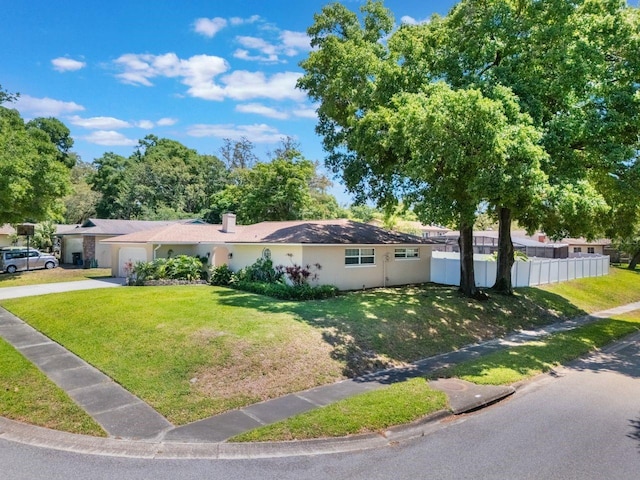 single story home with an attached garage, fence, concrete driveway, a front lawn, and stucco siding