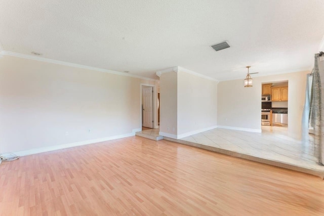 580 S Indigo Rd, Altamonte Springs, FL 32714 - unfurnished living room with light wood-style floors, ornamental molding, and a textured ceiling