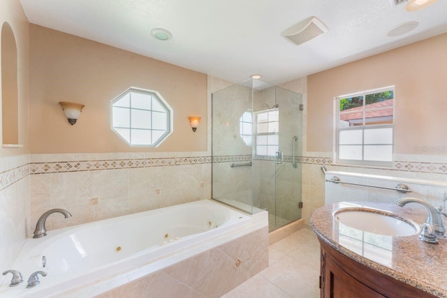580 S Indigo Rd, Altamonte Springs, FL 32714 - full bath featuring a stall shower, a jetted tub, healthy amount of natural light, vanity, and tile walls