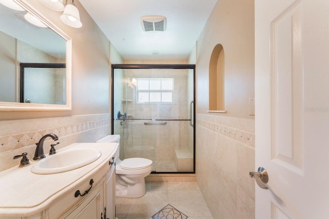 580 S Indigo Rd, Altamonte Springs, FL 32714 - bathroom with tile walls, a shower stall, vanity, tile patterned floors, and wainscoting