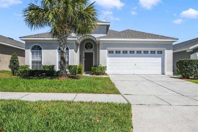 2237 Wyndham Palms Way, Kissimmee, FL 34747 - view of front of house featuring an attached garage, concrete driveway, stucco siding, and a front lawn