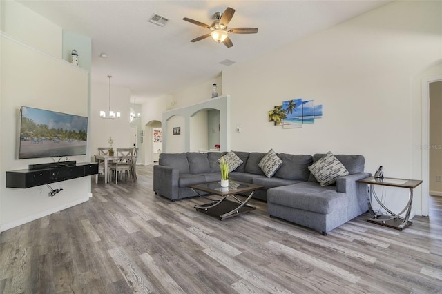 2237 Wyndham Palms Way, Kissimmee, FL 34747 - living area featuring visible vents, arched walkways, wood finished floors, and ceiling fan with notable chandelier
