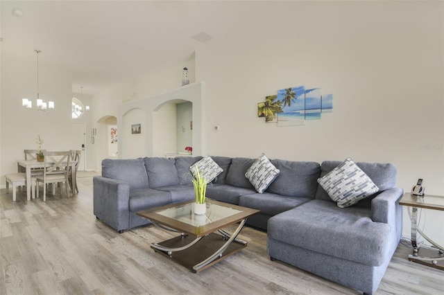2237 Wyndham Palms Way, Kissimmee, FL 34747 - living room featuring light wood finished floors, arched walkways, and an inviting chandelier