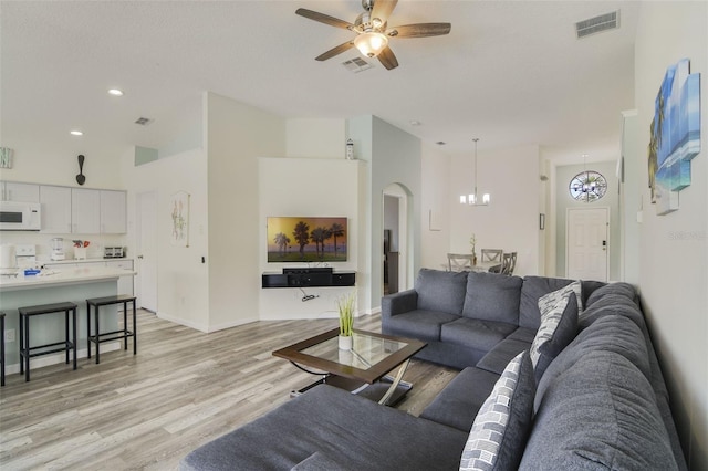 2237 Wyndham Palms Way, Kissimmee, FL 34747 - living area featuring visible vents, arched walkways, light wood-style floors, and ceiling fan with notable chandelier