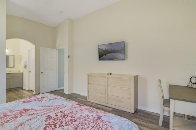 2237 Wyndham Palms Way, Kissimmee, FL 34747 - bedroom featuring arched walkways, wood finished floors, ensuite bathroom, and baseboards