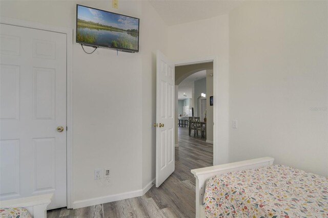 2237 Wyndham Palms Way, Kissimmee, FL 34747 - bedroom featuring baseboards, arched walkways, and wood finished floors