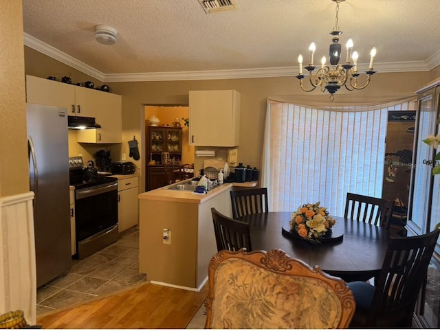 406 E Grove Ave, Lake Wales, FL 33853 - dining area featuring wood finished floors, a textured ceiling, a chandelier, and ornamental molding