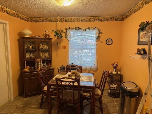 406 E Grove Ave, Lake Wales, FL 33853 - dining room with light tile patterned floors and a textured ceiling