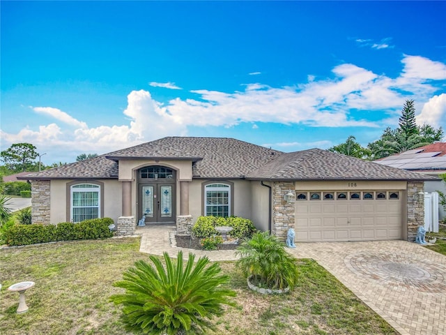 106 Meridian St, Davenport, FL 33837 - view of front of home with stucco siding, decorative driveway, french doors, and a garage