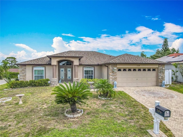 106 Meridian St, Davenport, FL 33837 - view of front of home with stucco siding, a front lawn, french doors, and a garage