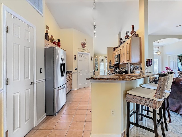 106 Meridian St, Davenport, FL 33837 - kitchen with a peninsula, arched walkways, visible vents, rail lighting, and appliances with stainless steel finishes