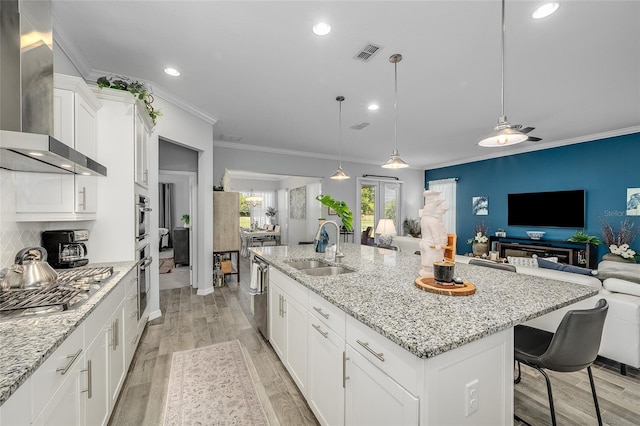 7957 Hanson Bay Pl, Kissimmee, FL 34747 - kitchen featuring a sink, stainless steel appliances, wall chimney exhaust hood, visible vents, and open floor plan