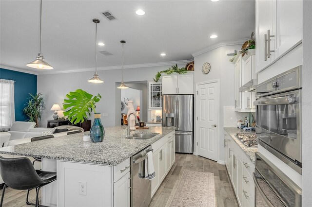 7957 Hanson Bay Pl, Kissimmee, FL 34747 - kitchen with appliances with stainless steel finishes, light wood finished floors, a sink, visible vents, and crown molding
