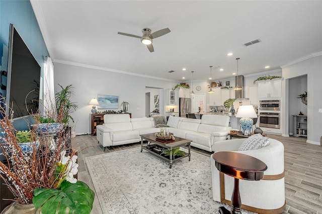 7957 Hanson Bay Pl, Kissimmee, FL 34747 - living room featuring light wood-style flooring, visible vents, recessed lighting, ornamental molding, and a ceiling fan