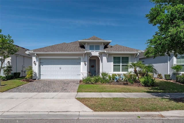 7957 Hanson Bay Pl, Kissimmee, FL 34747 - view of front of property with a garage, a shingled roof, stucco siding, and decorative driveway