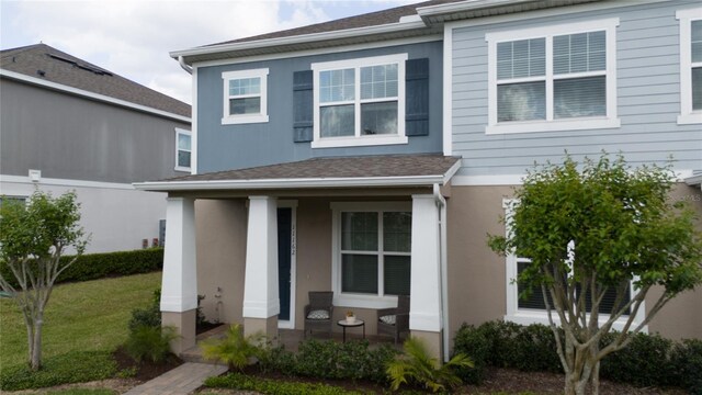11162 Hanlon Terrace Aly, Winter Garden, FL 34787 - traditional-style house featuring a porch, a front lawn, and stucco siding