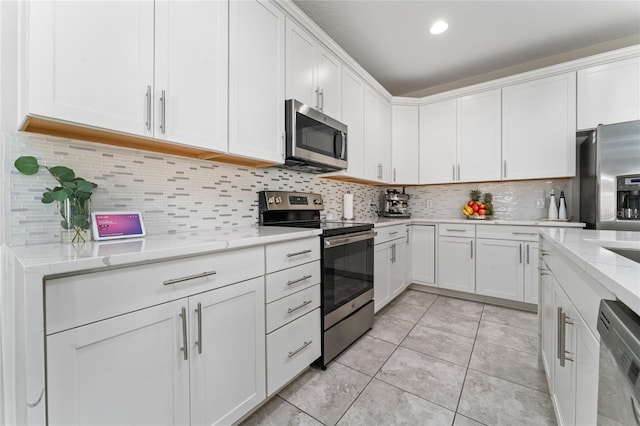 11162 Hanlon Terrace Aly, Winter Garden, FL 34787 - kitchen featuring light tile patterned floors, white cabinets, stainless steel appliances, decorative backsplash, and light stone counters