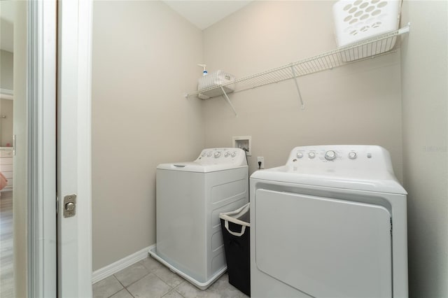 11162 Hanlon Terrace Aly, Winter Garden, FL 34787 - laundry room featuring light tile patterned floors, separate washer and dryer, laundry area, and baseboards