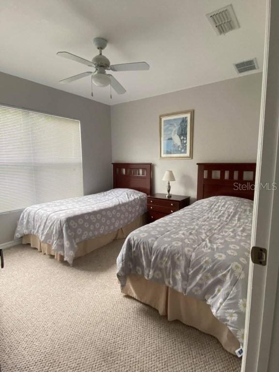 bedroom with carpet flooring, ceiling fan, and visible vents