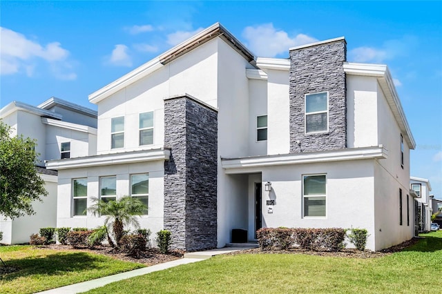 contemporary house featuring stucco siding, stone siding, and a front lawn