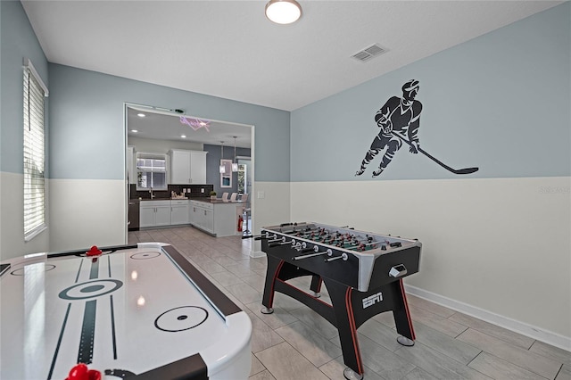 game room with visible vents and a sink