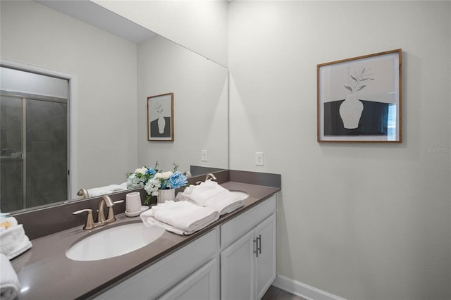 bathroom with double vanity, baseboards, and a sink