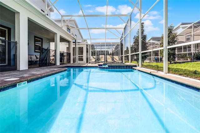 view of pool featuring a pool with connected hot tub, glass enclosure, and a patio