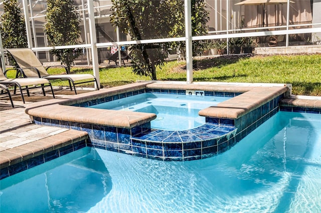 view of swimming pool featuring a lanai, a patio area, and a pool with connected hot tub