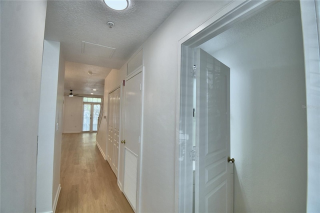 660 Celebration Ave Unit 240, Kissimmee, FL 34747 - hallway with light wood-style floors, a textured ceiling, and baseboards