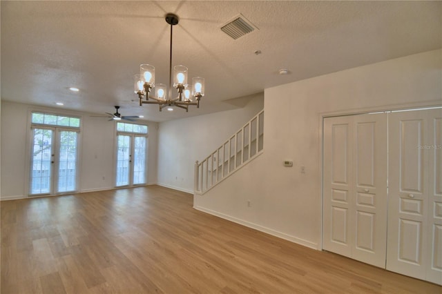 660 Celebration Ave Unit 240, Kissimmee, FL 34747 - unfurnished living room featuring french doors, light wood-type flooring, baseboards, visible vents, and stairs
