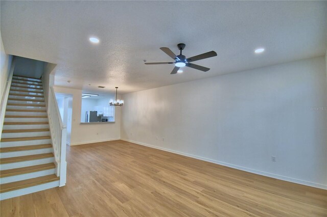 660 Celebration Ave Unit 240, Kissimmee, FL 34747 - unfurnished living room with stairway, ceiling fan with notable chandelier, light wood finished floors, baseboards, and recessed lighting