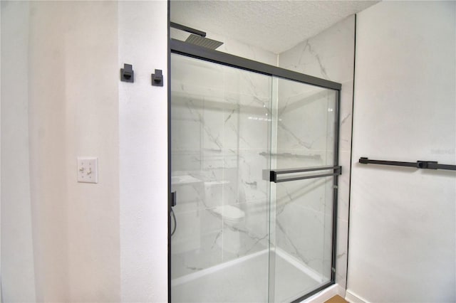 660 Celebration Ave Unit 240, Kissimmee, FL 34747 - full bathroom featuring a textured ceiling and a marble finish shower