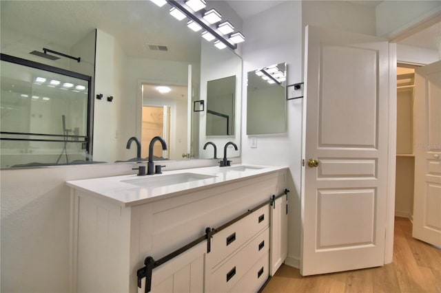 660 Celebration Ave Unit 240, Kissimmee, FL 34747 - bathroom featuring wood finished floors, visible vents, a sink, and double vanity