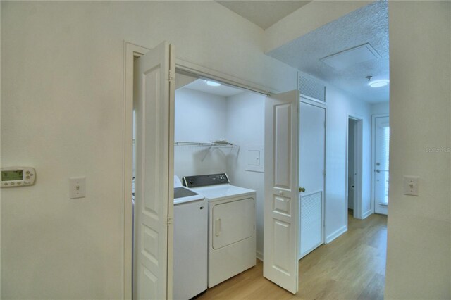 660 Celebration Ave Unit 240, Kissimmee, FL 34747 - washroom featuring visible vents, washer and clothes dryer, laundry area, and light wood-style floors