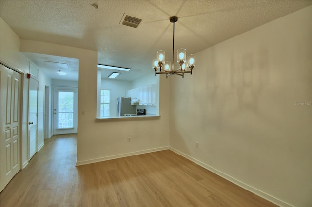 660 Celebration Ave Unit 240, Kissimmee, FL 34747 - unfurnished dining area with baseboards, visible vents, a textured ceiling, and light wood finished floors