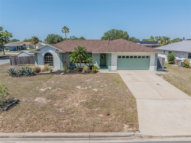 ranch-style home with stucco siding, fence, a front lawn, an attached garage, and driveway