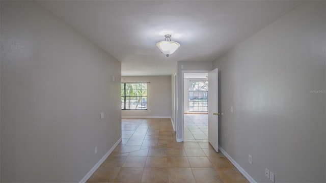 hallway with baseboards and light tile patterned flooring