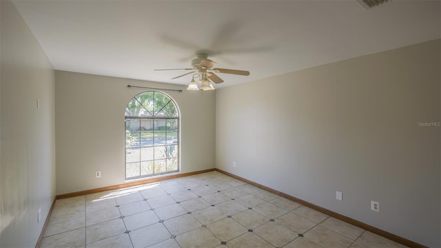 empty room featuring visible vents, ceiling fan, and baseboards